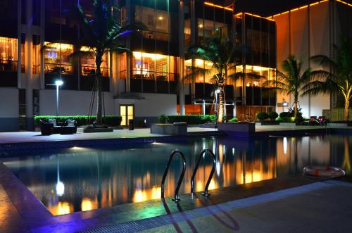 金沙萨Fleuve Congo Hotel By Blazon Hotels的一座游泳池,在晚上在建筑物前