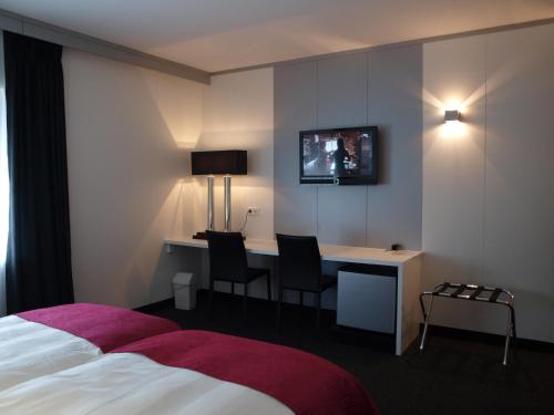 波莫洛赫波莫洛赫住宿加早餐旅馆的酒店客房设有一张床、一张书桌和一台电视机。
