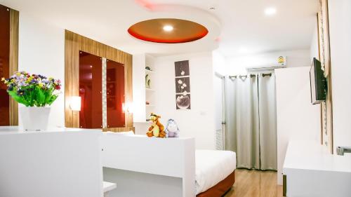 曼谷品克劳日落公寓的卧室配有白色的床和红色天花板