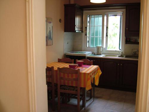 圣斯特凡诺斯Spiridoula apartments的厨房配有桌椅和窗户。