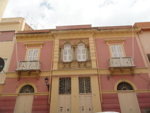 卡洛福泰Casa Tonina的粉红色的建筑,设有白色的窗户和门
