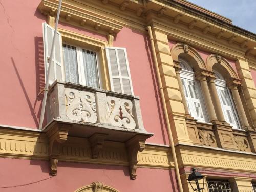 卡洛福泰Casa Tonina的粉红色和黄色的建筑设有阳台