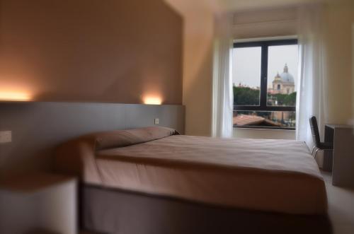 阿西西TH Assisi - Casa Leonori的一间卧室设有一张床和一个美景窗户。