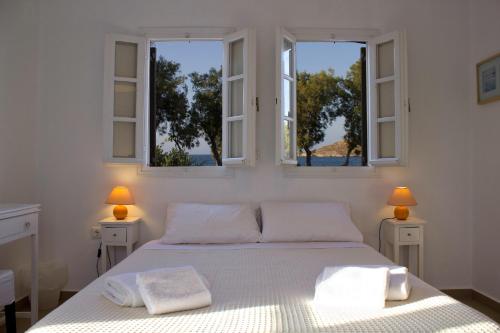 纳乌萨Almira Suites - Seafront - Naousa Paros的卧室配有白色床和2扇窗户