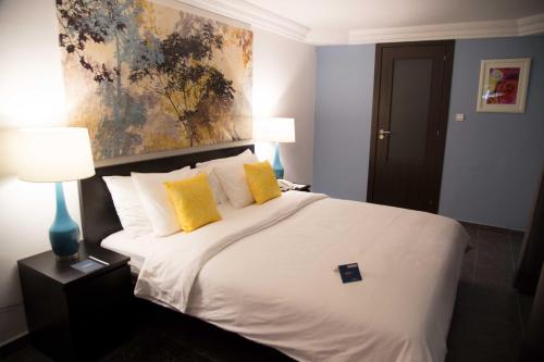 努瓦克肖特Hôtel Semiramis City Center的卧室配有一张带黄色枕头的大型白色床。