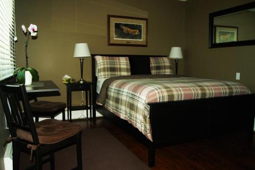 平彻克里克Stardust Inn and Chalets的一间卧室配有一张带桌子和椅子的床