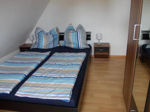 PutgartenFerienwohnung auf Rügen ganz oben的一张带蓝色和白色枕头的床