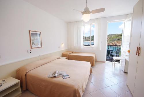 卡波利韦里迪诺酒店的酒店客房设有两张床和一个阳台。