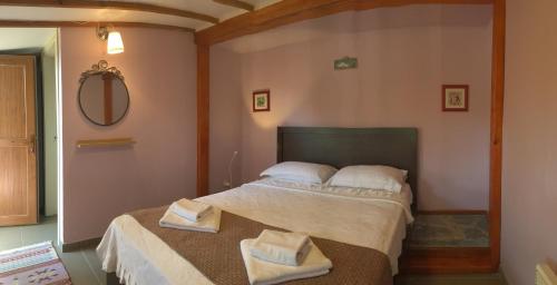 博兹贾阿达岛Nar Bağevi的一间卧室配有一张床,上面有两条毛巾