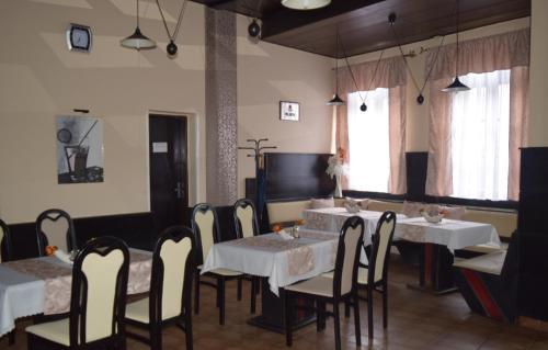 科马尔诺环形旅馆的一间设有白色桌椅和窗户的用餐室