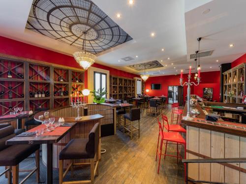 佩兹纳斯Garrigae Distillerie de Pezenas - Hotellerie & Spa的一间拥有红色墙壁的餐厅以及一间配备了桌椅的酒吧