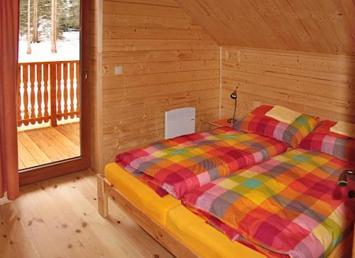 迪马诺卡多林纳Chata Iľanovka的小木屋内一间卧室,配有一张床