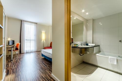 萨拉戈萨YIT萨拉戈萨酒店的酒店客房设有带一张床和浴缸的浴室