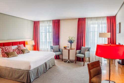 基尔肯尼基尔肯尼佩恩布鲁克酒店的酒店客房设有一张大床和红色窗帘