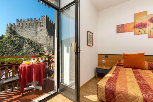 滕诺Hotel Antica Croce - Gardaslowemotion的一间卧室设有一张床,阳台设有城堡