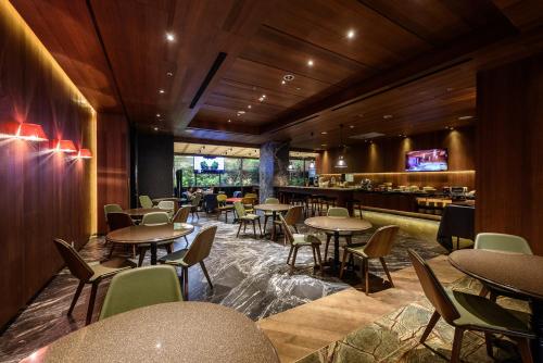 台中市薆悅酒店台中館的一间带桌椅的餐厅和一间酒吧
