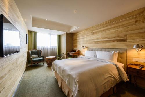 台中市薆悅酒店台中館的酒店客房带一张大床和一把椅子