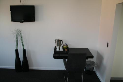 曲博伦迪伯伦海滨酒店的一张带椅子的黑桌和墙上的电视