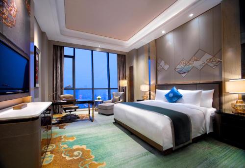 呼和浩特呼和浩特富力万达文华酒店的酒店客房设有一张大床和一台电视。