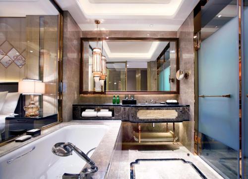 呼和浩特呼和浩特富力万达文华酒店的一间带浴缸和大镜子的浴室