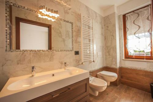 佩斯基耶拉德加达B&B Holidays Artisti的一间带水槽、卫生间和镜子的浴室