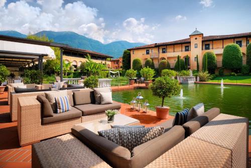 阿斯科纳阿斯科纳贾尔迪诺酒店的一座建筑前方的庭院,设有长沙发和池塘