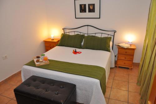法马拉Acogedor apartamento en la playa的卧室配有一张带绿毯的大型白色床