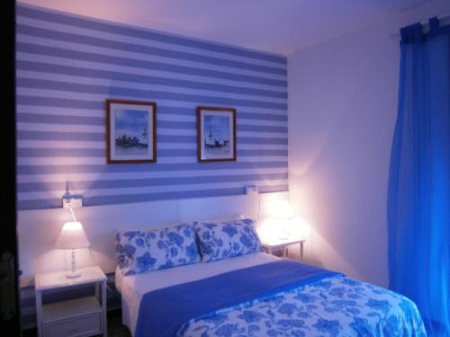 菲格拉斯唐佩佩旅馆的一间卧室配有蓝色条纹墙和一张床