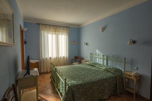 菲维扎诺Albergo Il Sicomoro的一间卧室设有一张绿色的床和一个窗户。