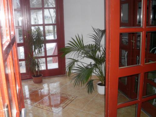 德布勒森潘基欧站酒店的一间种植了盆栽植物的房间和一扇红色的门