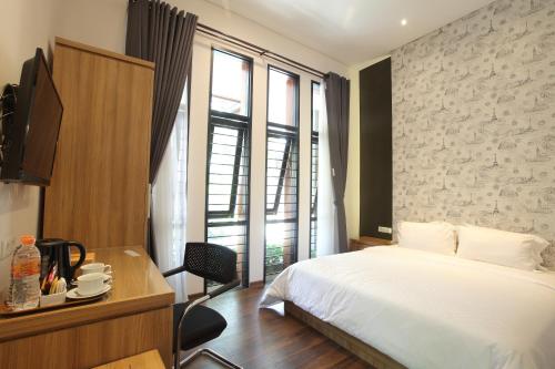 万隆达格特库安卡萨14号旅馆的酒店客房设有一张床、一张书桌和窗户。