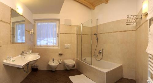 塞尔瓦迪加尔代纳山谷Residence Villa Funtanes的一间带水槽、浴缸和卫生间的浴室