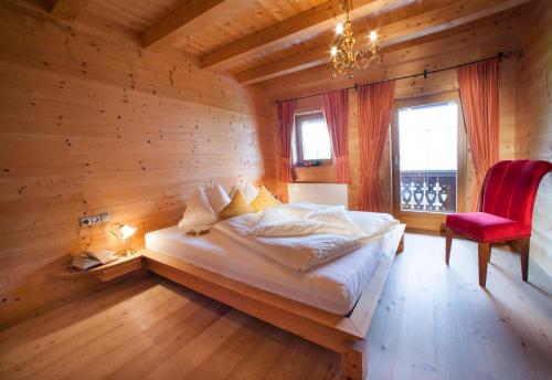 菲根贝格Alpen-Chalet-Pankraz的一间卧室配有一张床和一张红色椅子