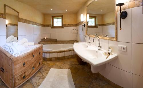 菲根贝格Alpen-Chalet-Pankraz的带浴缸、两个盥洗盆和浴缸的浴室。