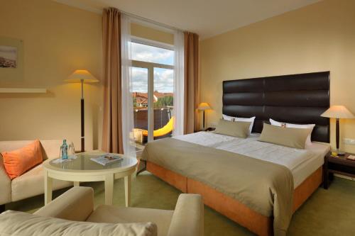 诺伊鲁平Resort Mark Brandenburg & Fontane Therme的酒店客房配有一张床铺和一张桌子。