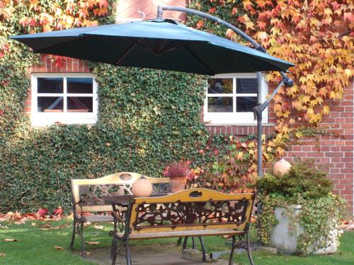 RekenGästezimmer Lammersmann的院子里带雨伞的长凳