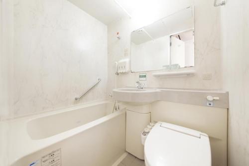 甲府甲府华盛顿广场酒店的白色的浴室设有卫生间和水槽。