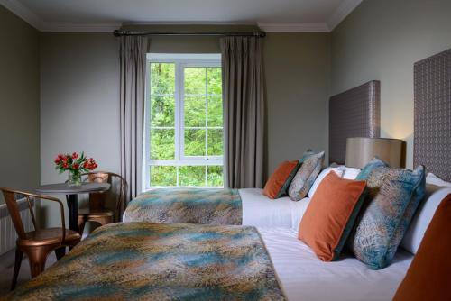 基拉尼The Reserve at Muckross Park的酒店客房设有两张床和窗户。