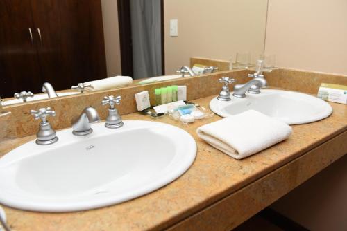 拉斯格路塔斯Hotel y Casino Del Río - Las Grutas的浴室柜台设有两个盥洗盆和镜子
