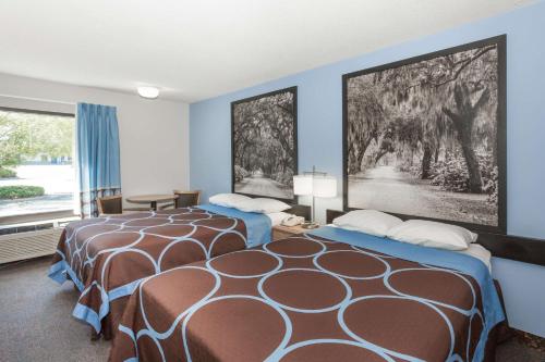 瓦尔多斯塔Super 8 by Wyndham Valdosta GA I-75的蓝色墙壁客房的两张床