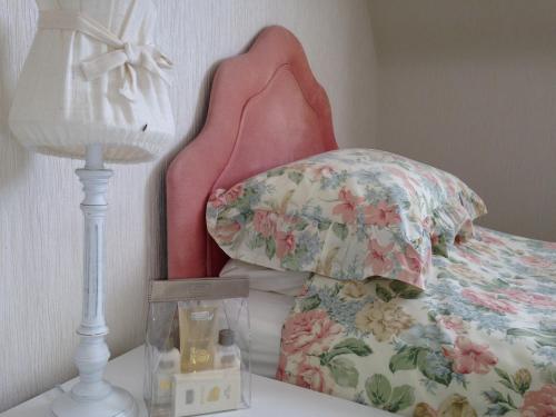 TurriffEastwood Cottage的一间卧室配有一张带枕头和灯的床