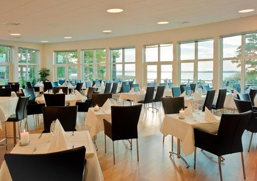 HörbyRingsjöstrand Hotel的用餐室设有桌椅和窗户。