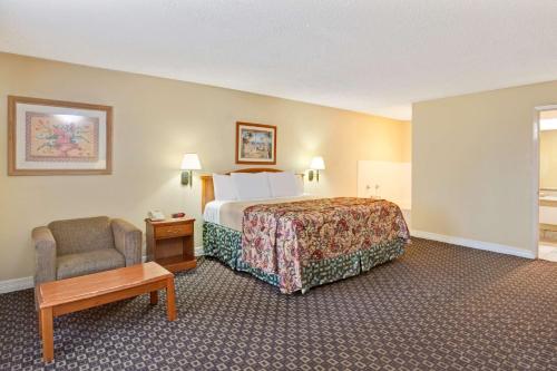 拉波特Americas Best Value Inn & Suites La Porte/Houston的配有一张床和一把椅子的酒店客房