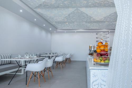 Provatas黄金米洛斯海滩酒店的用餐室配有桌椅和水果展示
