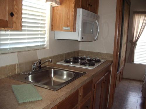 卡顿伍德Verde Valley One-Bedroom Park Model Cabin 14的厨房配有水槽和微波炉