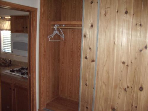 卡顿伍德Verde Valley One-Bedroom Park Model Cabin 13的厨房设有木镶板墙和步入式淋浴间。