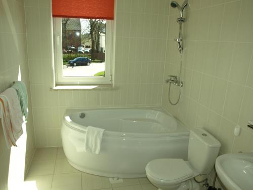 图库姆斯图库马乐杜思哈勒酒店的带浴缸、卫生间和窗户的浴室