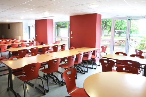 米卢斯米卢斯青年旅舍的一间空的教室,里面设有桌椅和窗户
