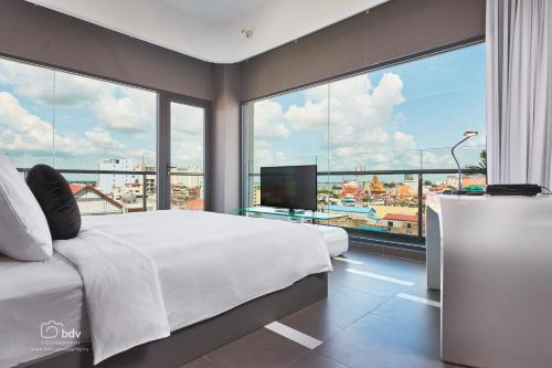 金边太阳月亮城市酒店的一间卧室设有一张大床和一个大窗户