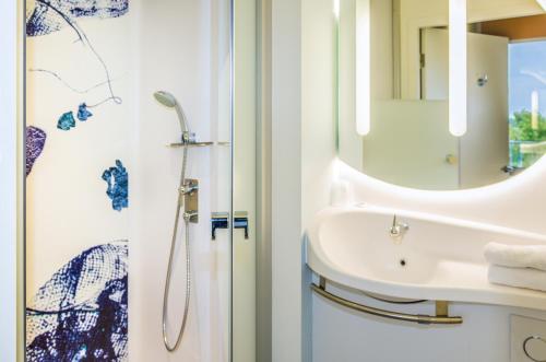 克莱蒙费朗Ibis Budget Clermont Ferrand - Le Brezet - Aeroport的一间带水槽和镜子的浴室
